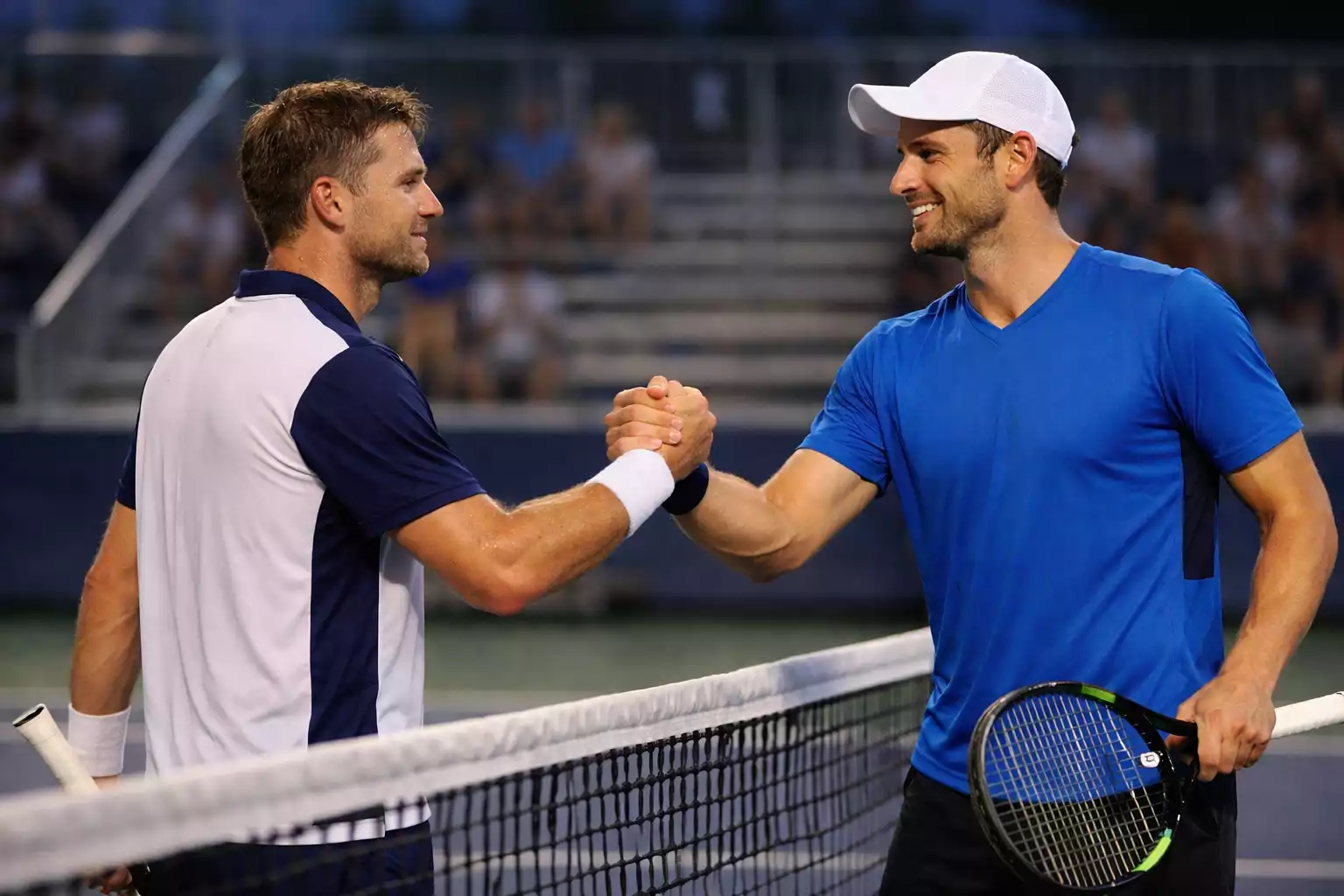 Twee tennisspelers schudden handen na wedstrijd